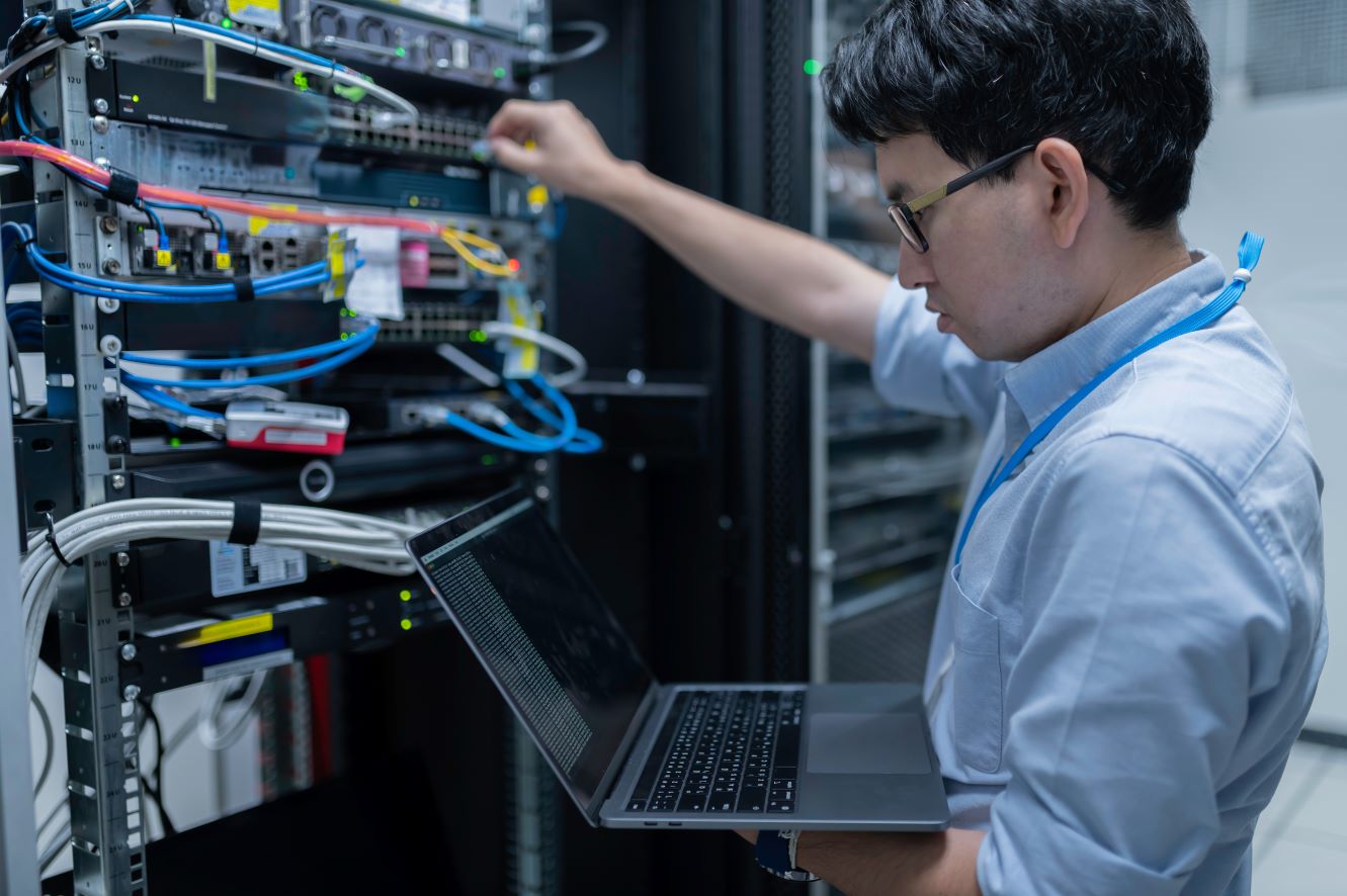IT engineer working is a comms cabinet